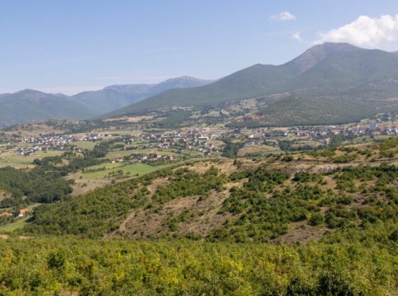 The town of Golaj in Northern Albania, with villas being built and surrounded by mountains and trees.