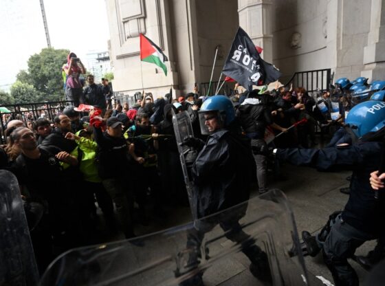 Protesters clash with riot police at a train station.