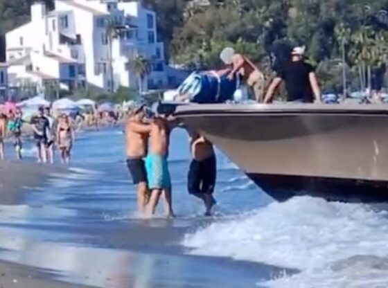 Drug dealers unloading drugs from a boat on a crowded beach.