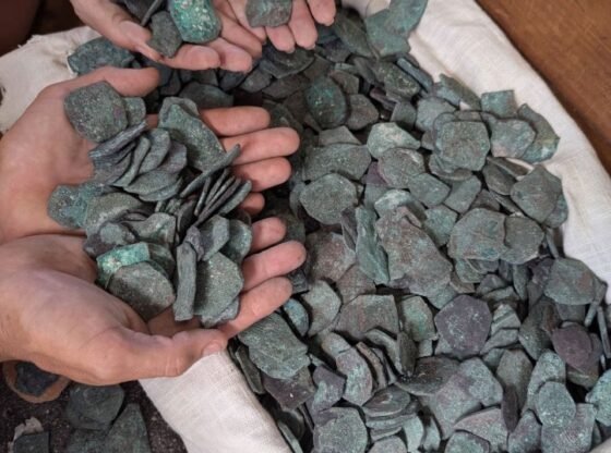 Hands holding recovered gold and silver coins from the 1715 Treasure Fleet shipwreck.