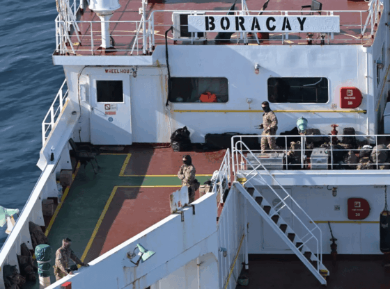 Three armed personnel in tactical gear on the deck of the vessel "BORACAY."