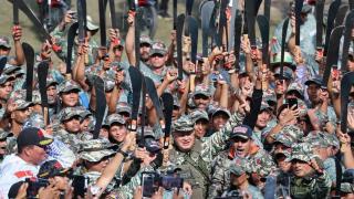 Diosdado Cabella raises a machete alongside a group of militiamen from Carayaca.