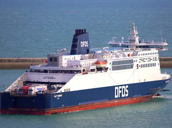 DFDS ferry sailing near Dover with a clear blue sky and calm sea.