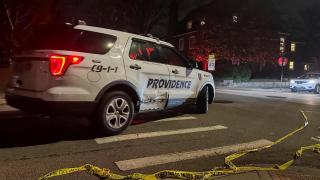 A police car passes police tape in the street following a shooting at Brown University in Providence.
