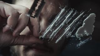 A boy snorts a line of cocaine.